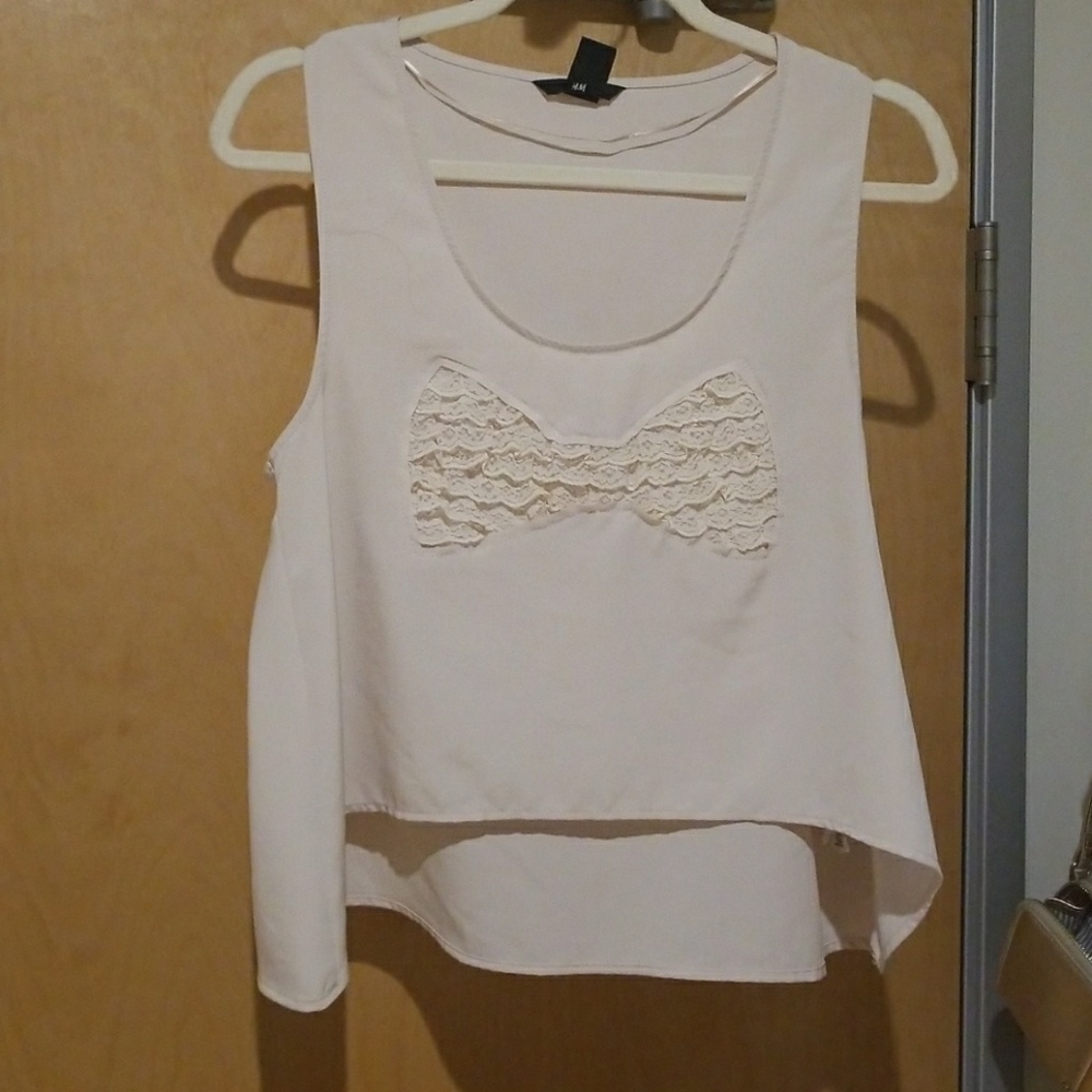 Off-white loose sleeveless top with ruffle bow